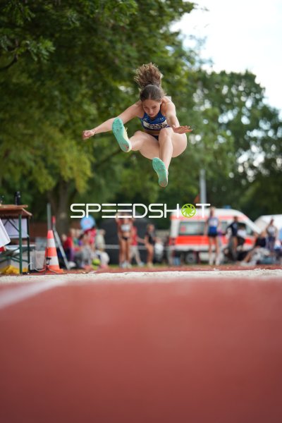 Weitsprung-Athletin im Flug über der Sandgrube in Hannover