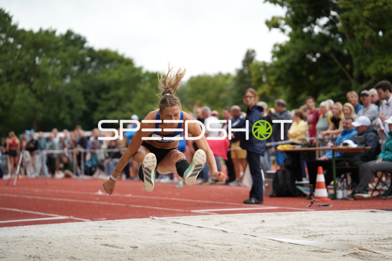Weitsprung-Athletin im Flug über der Sandgrube in Hannover