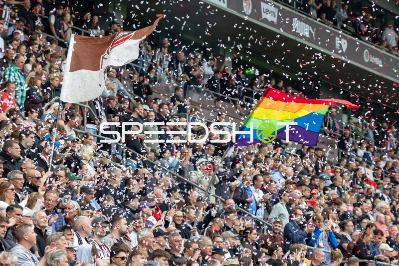 FC St. Pauli Fans feiern mit Konfetti und Regenbogenfahne im Millerntor