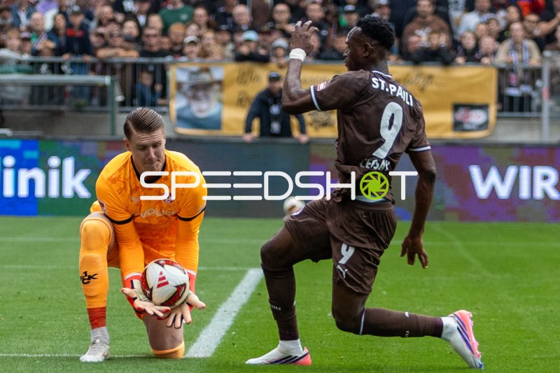 Julian Krahl (#1; 1. FC Kaiserslautern) sichert den Ball gegen Abdoulie Ceesay (#9; FC St. Pauli)