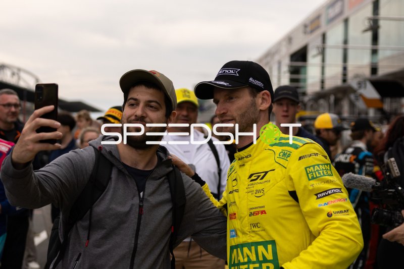Maro Engel im gelben Mann-Filter-Overall macht Selfie mit Fan am Nürburgring