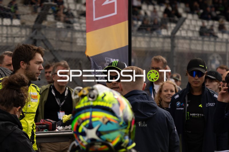 Fahrerlager-Szene am Nürburgring mit Helm und Teamcrews