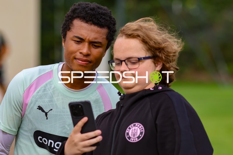 FC St. Pauli Spieler und Fan schauen gemeinsam aufs Smartphone