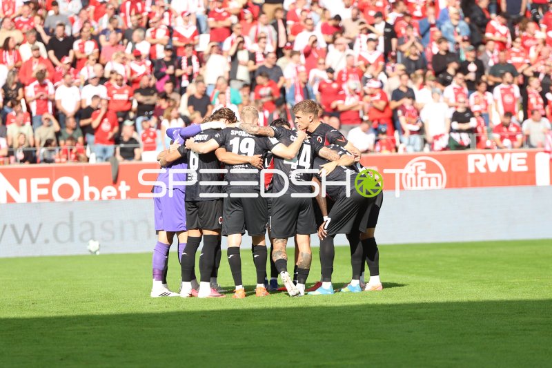 FC Viktoria Köln bildet Mannschaftskreis vor vollem Essener Fanblock