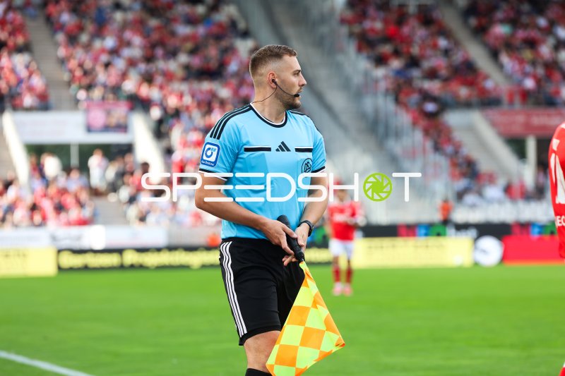Schiedsrichter-Assistent mit Fahne am Spielfeldrand
