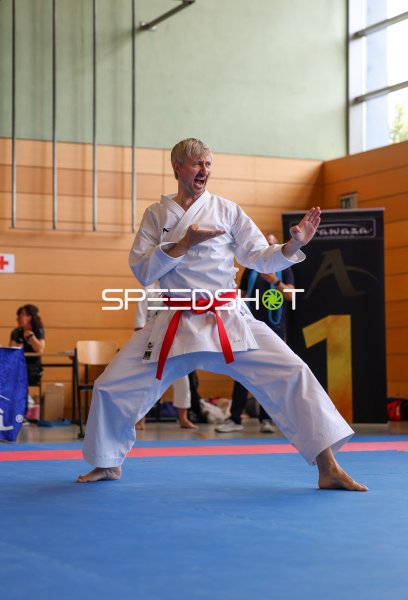 Karateka mit rotem Gürtel in ausdrucksstarker Kata-Pose