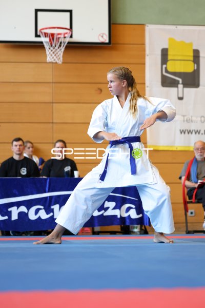 Kata-Athletin mit blauem Gürtel in konzentrierter Wettkampfposition