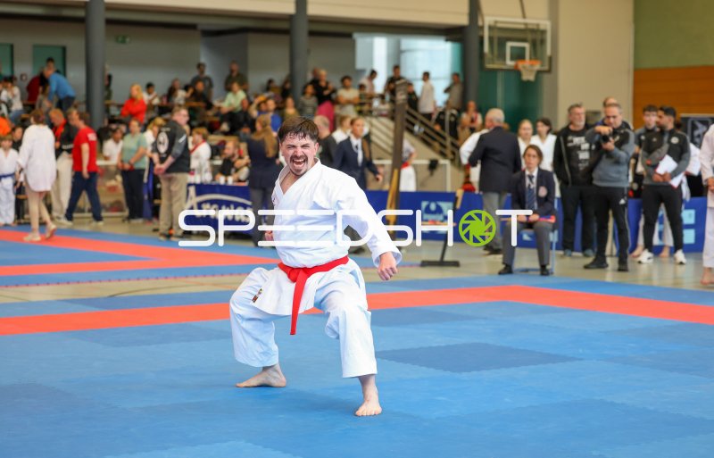 Karateka im weißen Gi mit rotem Gürtel bei intensiver Kata-Vorführung in Eckernförde