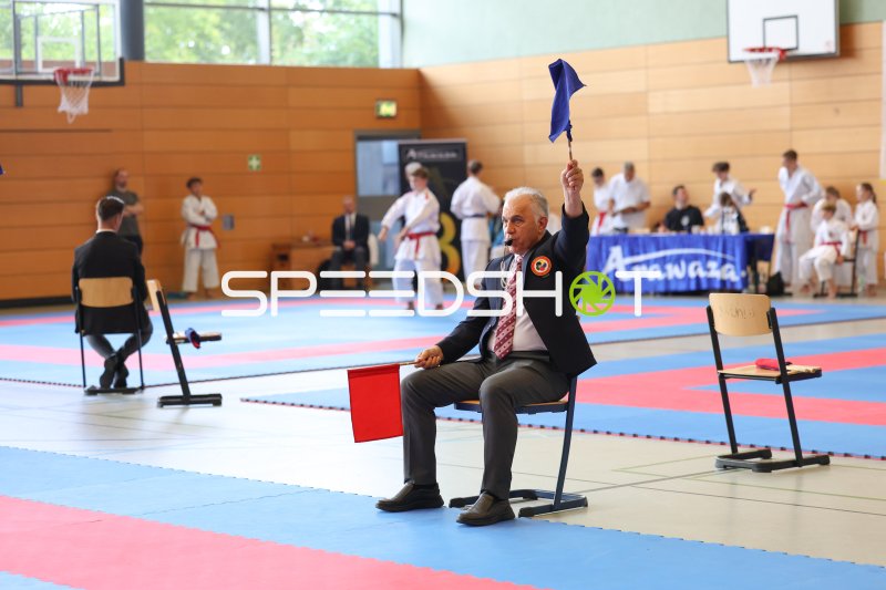 Kampfrichter hebt blaue Fahne bei Karate-Wettkampf in Eckernförde
