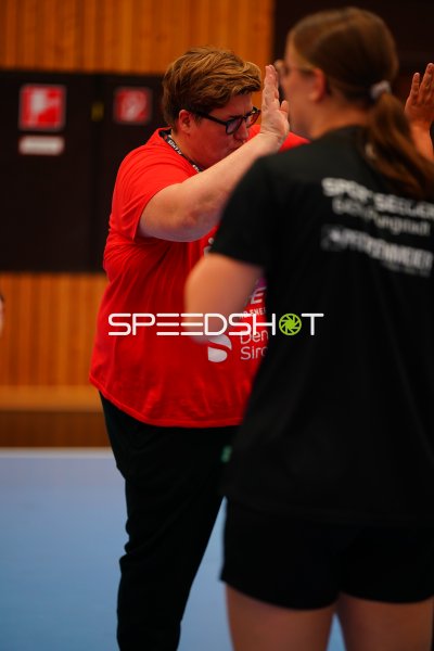 Trainerin gibt Spielerin ein High-Five in der Halle