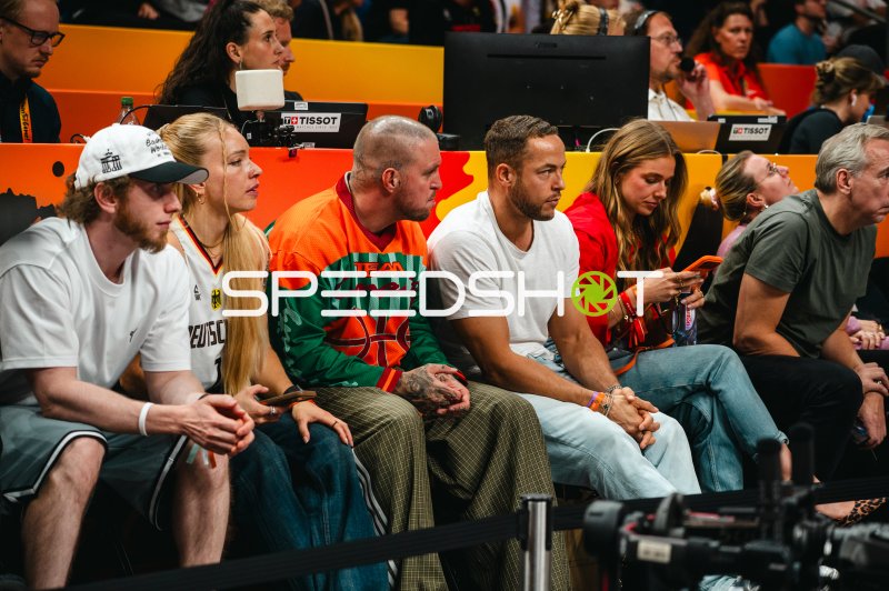 Zuschauer sitzen dicht gedrängt am Spielfeldrand einer Basketballarena