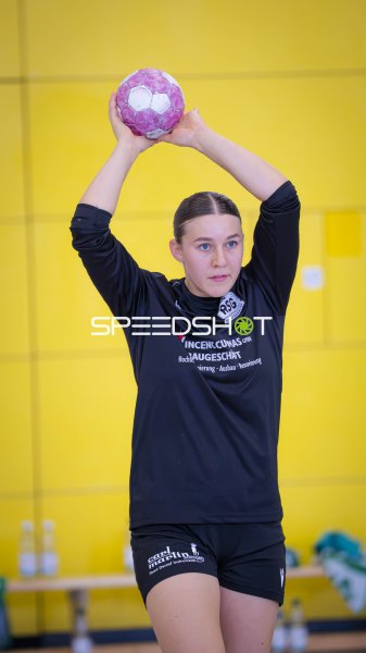 Handballspielerin bei Wurfvorbereitung mit erhobenem Ball