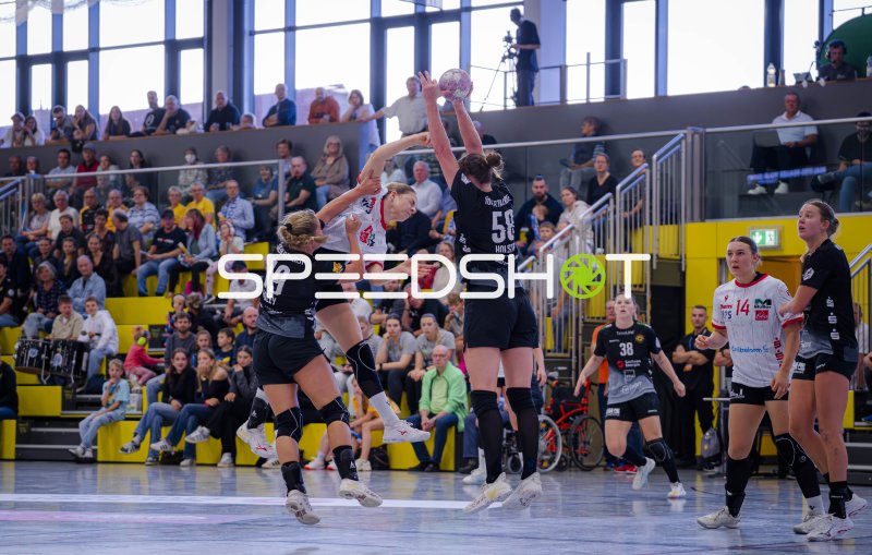 Handballerin springt zum Wurf gegen doppelte Deckung