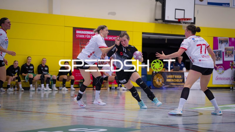 Rückraumspielerin (#11) setzt sich im Zweikampf gegen Nummer 77 durch