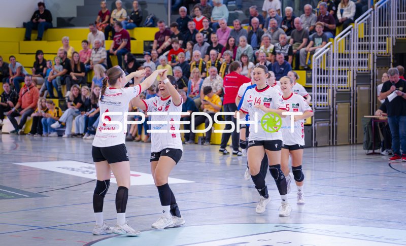 Handballerinnen bejubeln Treffer beim Zweikampf am Spielfeldrand