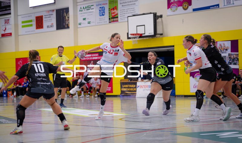 Sprungwurf einer Handballspielerin (#42) gegen die Abwehr
