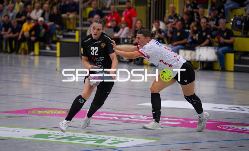 Rückraumspielerin (#32) im Duell mit Gegenspielerin in Weiß