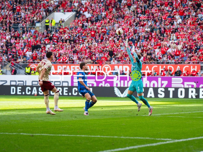 Torwart von Eintracht Braunschweig faustet Ball vor Kaiserslautern-Spieler