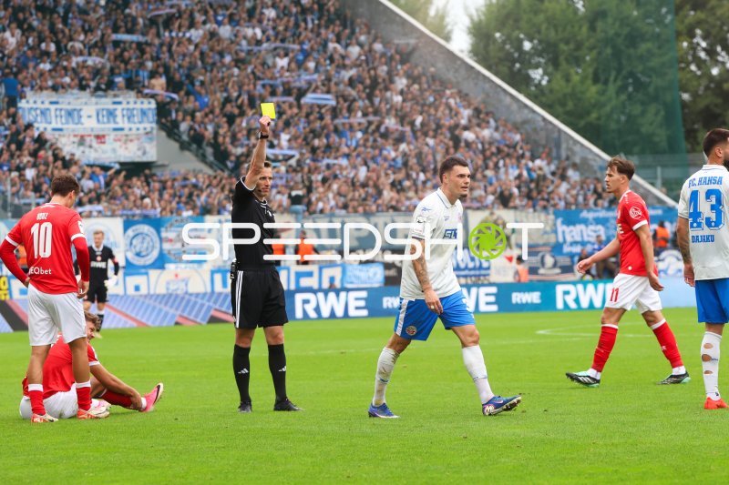 Schiedsrichter zeigt Gelbe Karte während FC Hansa Rostock gegen Rot-Weiss Essen