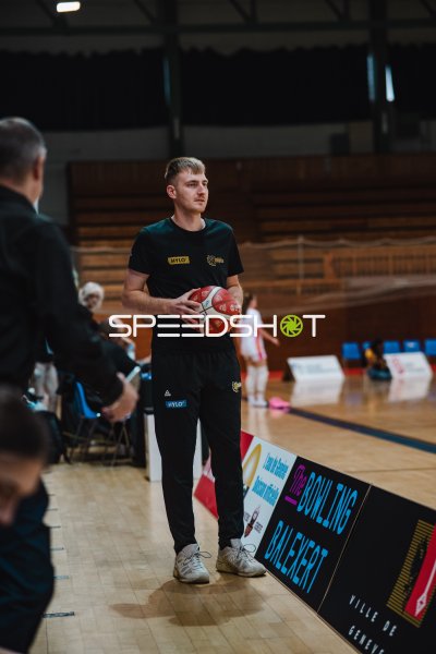 Trainer mit Basketball in der Halle