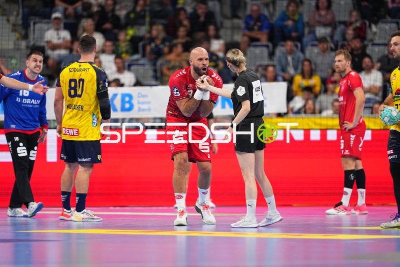 Adrian Sipos (#8; MT Melsungen) im Gespräch mit der Schiedsrichterin