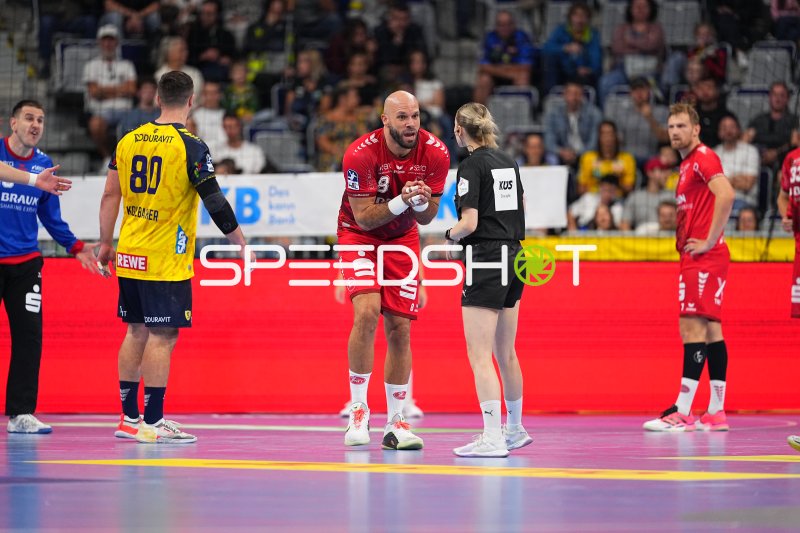 Adrian Sipos (#8; MT Melsungen) im Gespräch mit der Schiedsrichterin