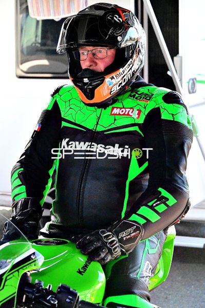 Kawasaki-Motorradfahrer in neongrüner Rennkleidung auf der Boxengasse