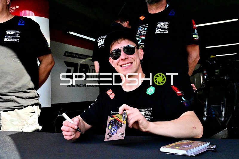 Rennfahrer signiert Autogramme in der Motorsport-Hospitality