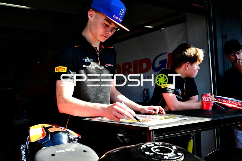 Rennfahrer signiert Autogramme in der Motorsport-Hospitality