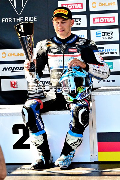 Motorrad-Rennfahrer mit Pokal auf dem Podium in Hockenheim
