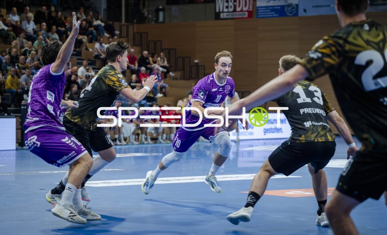Spieler von HC Elbflorenz im Angriff gegen die Abwehr von TV Hüttenberg