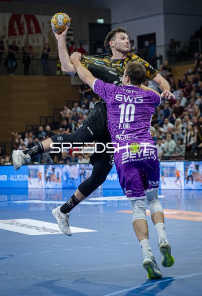 Spieler von HC Elbflorenz im Sprungwurf gegen Abwehr von TV Hüttenberg