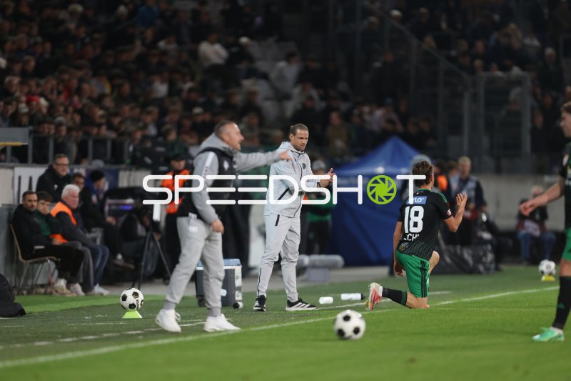 Trainer instruiert Spieler während Spielunterbrechung im Tivoli Stadion