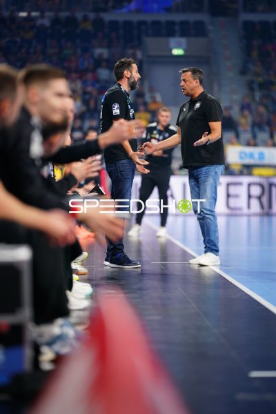 Zwei Männer im Gespräch an der Seitenlinie bei Handball-Bundesliga-Spiel
