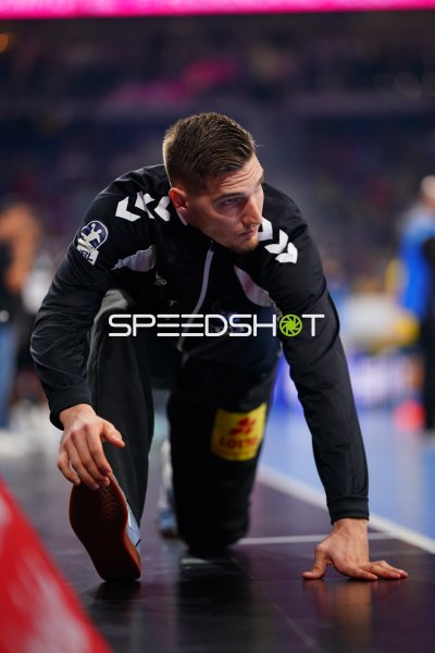 Dominik Kuzmanović (#1; SC Magdeburg) dehnt sich vor dem Spiel am Spielfeldrand