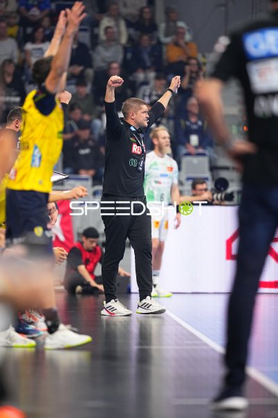 Trainer jubelt mit erhobenen Fäusten an der Seitenlinie, dahinter Matthias Musche (#6; SC Magdeburg)