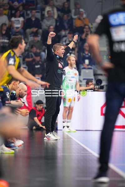 Trainer jubelt mit erhobenen Armen an der Seitenlinie, dahinter Matthias Musche (#6; SC Magdeburg)