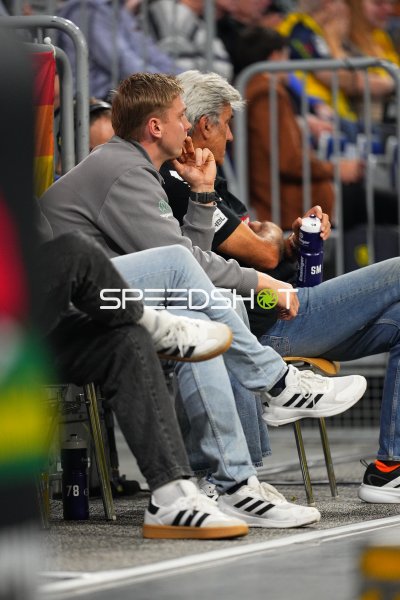 Zwei Männer verfolgen das Handballspiel von der Bank in der SAP Arena