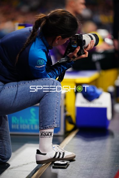 Fotografin kniet mit Teleobjektiv am Spielfeldrand in der SAP Arena