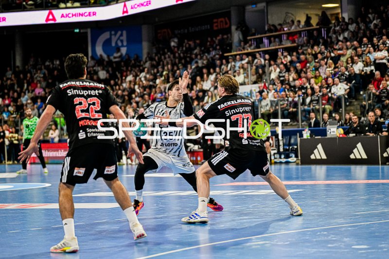 Angreifer vom THW Kiel im Sprungwurf gegen die Abwehr des HC Erlangen