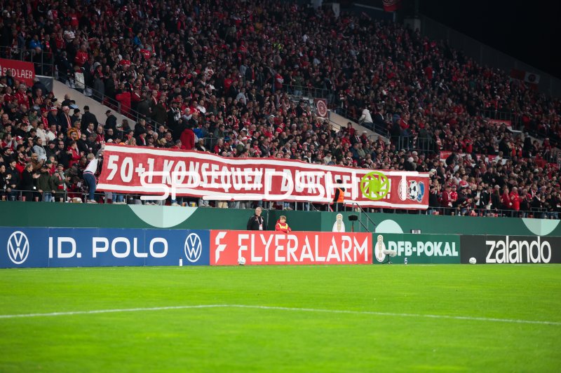 Fans von Rot-Weiss Essen zeigen Banner »50+1 konsequent durchsetzen!« im Stadion an der Hafenstraße