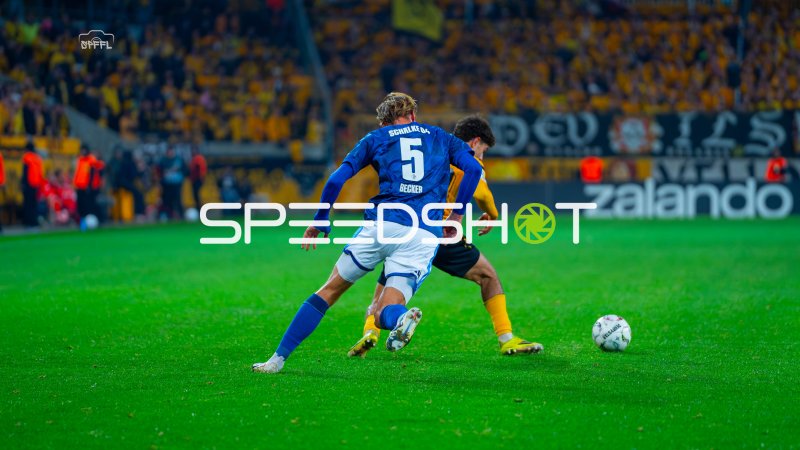 Schalke-Spieler (#5) führt den Ball im Duell gegen Dresdner Gegenspieler