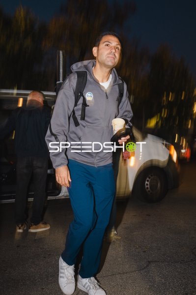 Person im Alba-Berlin-Hoodie mit Kaffeebecher bei Nacht am Straßenrand