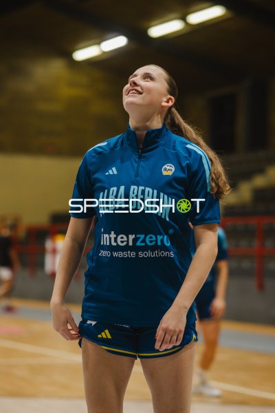 Basketballerin im Alba-Berlin-Shirt schaut lächelnd nach oben