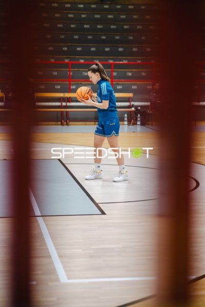 Basketballspielerin wärmt sich mit Ball im PalaAllende auf