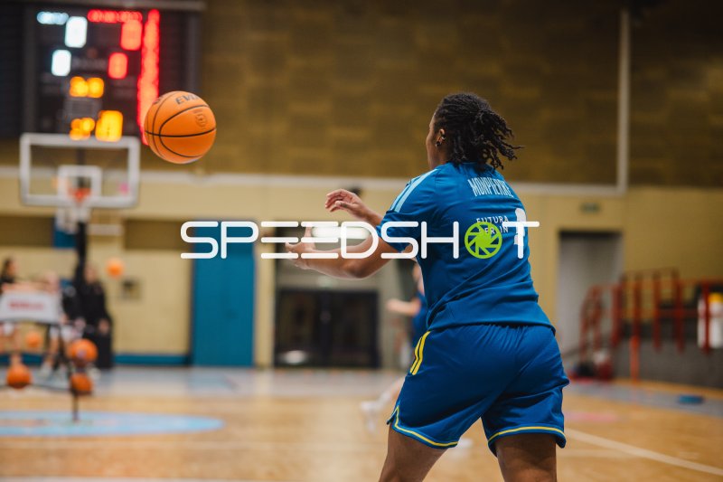 Basketballspielerin passt den Ball in der Sporthalle von Meiland