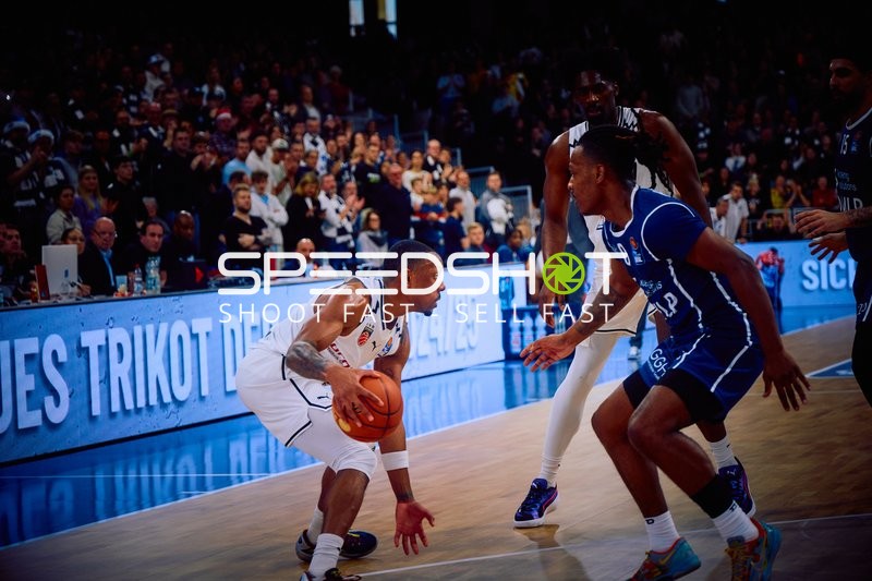 Ein Spieler von Brose Bamberg dribbelt den Ball und wird von einem Verteidiger der MLP Academics Heidelberg gedeckt.