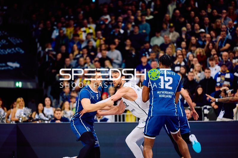 Brose Bamberg-Spieler versucht, sich gegen die Verteidigung von MLP Academics Heidelberg durchzusetzen