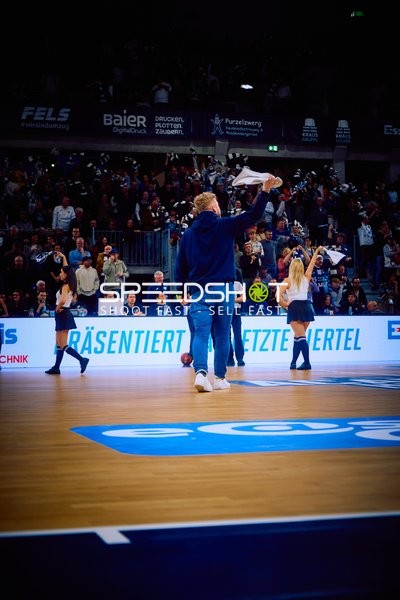 Fans auf dem Spielfeld feiern und winken mit Tüchern.