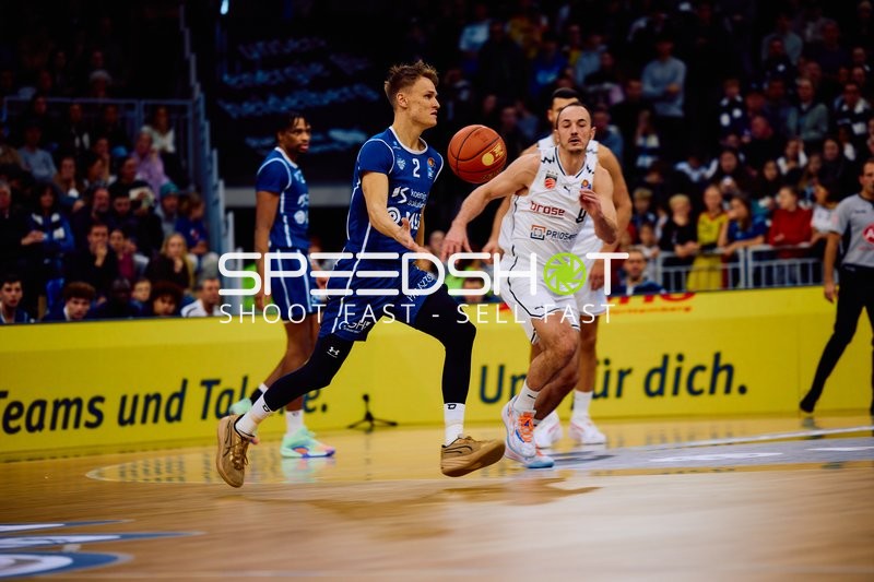 Ein Spieler von MLP Academics Heidelberg dribbelt den Ball, während Karsten Tadda von Brose Bamberg versucht zu verteidigen.